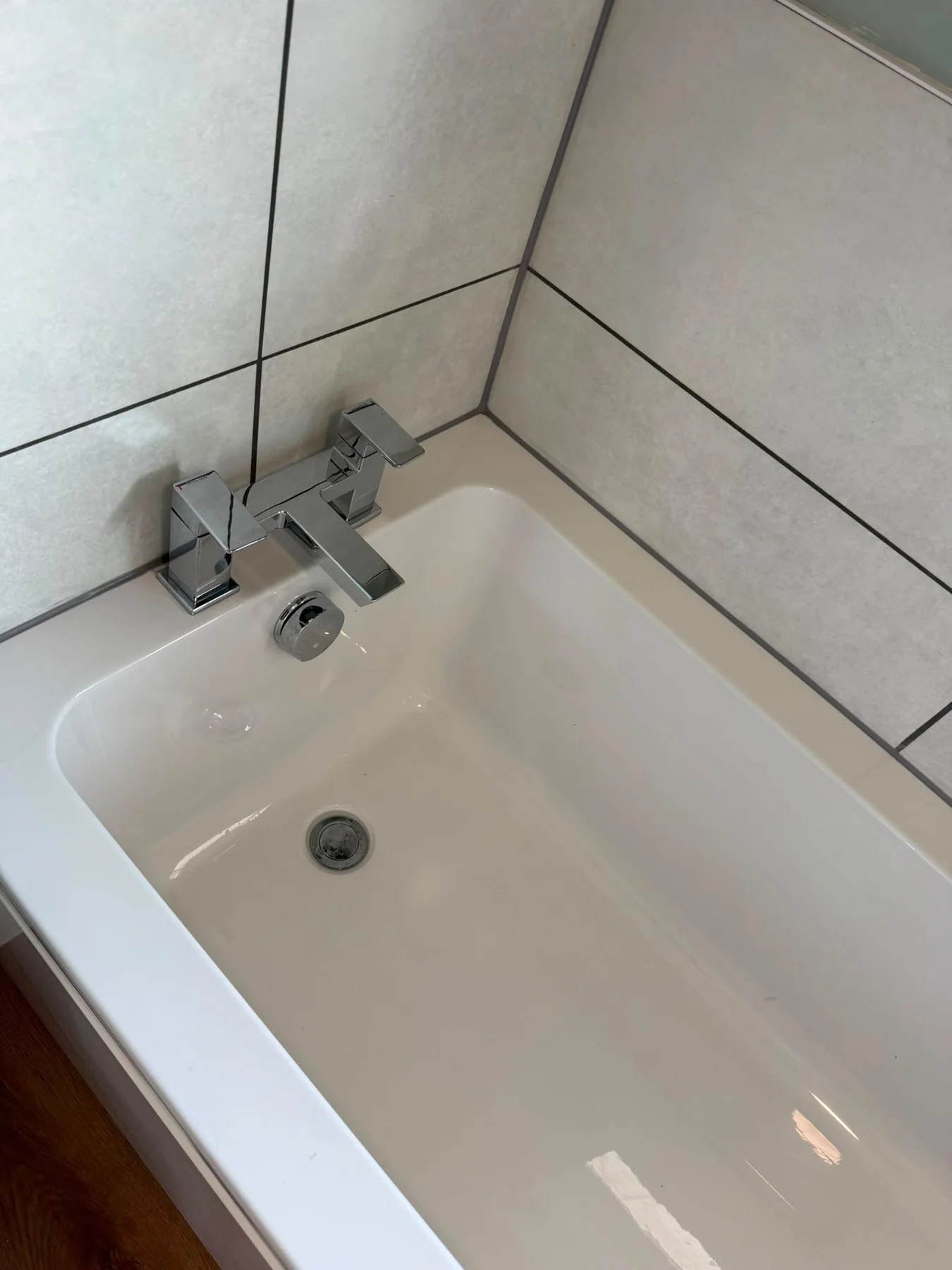 Polished bath, taps and tiled surround
